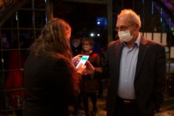 A man presents his "green passport," proof that he is vaccinated against the coronavirus, on opening night at the Khan Theater for a performance where all guests were required to show proof of vaccination or full recovery from the virus, in Jerusalem