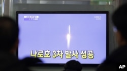Warga Korea Selatan mengamati televisi di sebuah stasiun kereta di Seoul, Korea Selatan yang menayangkan peluncuran roket pertama Korea Selatan (30/1).