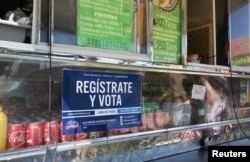 FILE - A voter registration sign is seen on a taco truck, as part of the U.S. Hispanic Chamber of Commerce's "Guac the Vote" campaign, in Houston, Texas, Sept. 29, 2016.