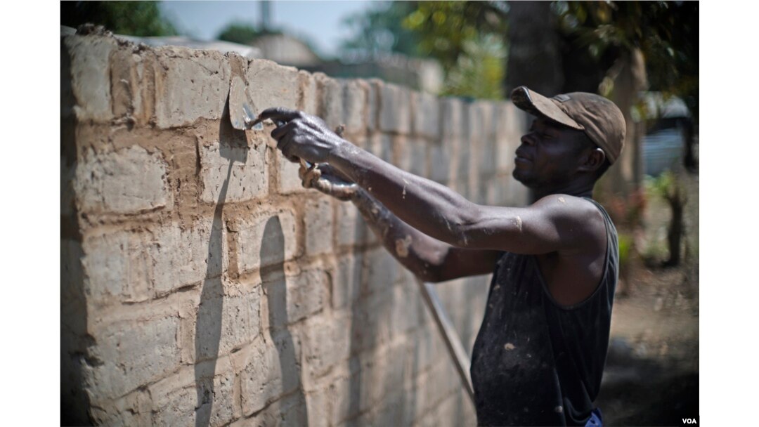 A Central African Republic man works to reconstruct a home in the PK5 neighborhood of Bangui in February 2017. (Z. Baddorf/VOA)