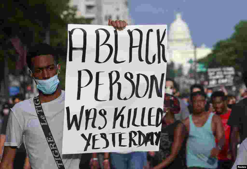 A protester holds a sign as he attends a protest near the White House during a rally and march against the death in Minneapolis police custody of African-American man George Floyd, in Washington, U.S. May 29, 2020. REUTERS/Jonathan Ernst