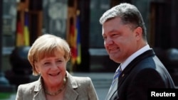 ယူကရန်းသမ္မတ Petro Poroshenko (ယာ) နဲ့ ဂျာမန်ဝန်ကြီးချုပ် Angela Merkel တို့ Kyiv မြို့မှာ တွေ့ဆုံစဉ်။ (သြဂုတ်လ ၂၃၊ ၂၀၁၄)