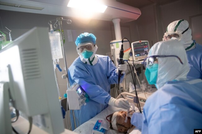 Medical staff treat a COVID-19 coronavirus patient at a hospital in Wuhan, in China's central Hubei province on March 19, 2020