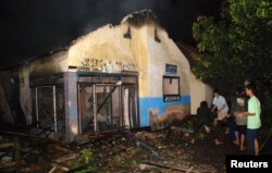 Pengikut aliran minoritas Islam Ahmadiyah memadamkan masjid yang terbakar di Desa Ciampea, Jawa Barat, 1 Oktober 2010. (Foto: Reuters)