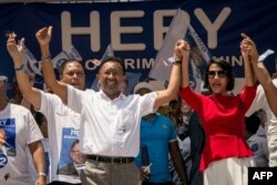 Former Malagasy President and presidential candidate Hery Rajaonarimampianina and and his wife Voahangy Rajaonarimampianina attend a campaign rally, Nov. 4, 2018, at the Colyseum stadium in Antananarivo.