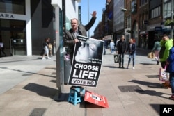 FILE - An anti-abortion campaigner holds up a banner as he speaks, in Dublin, Ireland, on May 17, 2018, ahead of the May 25 abortion referendum.