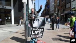 FILE - An anti-abortion campaigner holds up a banner as he speaks, in Dublin, Ireland, on May 17, 2018, ahead of the May 25 abortion referendum.