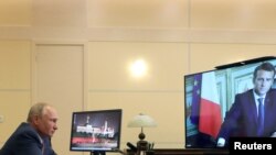 FILE - Russia's President Vladimir Putin speaks with his French counterpart Emmanuel Macron during a video conference call at the Novo-Ogaryovo state residence outside Moscow, Russia, June 26, 2020.