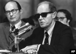 FILE - Convicted Watergate conspiritor E. Howard Hunt, wearing dark glasses, begins his seconds day of testimony before the Senate Watergate Committee in this Sept. 25, 1973 photo in Washington, D.C. Hunt helped organize the Watergate break-in that led to the greatest scandal in American political history and the downfall of Richard Nixon's presidency.