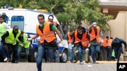 Paramedics run outside the Westgate Mall in Nairobi after heavy shooting, Sept. 23, 2013.