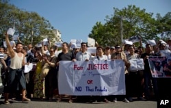 Protesters display messages near the Thai Embassy in Yangon, Myanmar, Friday, Dec. 25, 2015.