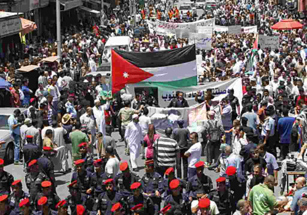 Jordanian police form a line separating the anti-government protesters (back) from government supporters during a demonstration after Friday prayers in Amman, June 10, 2011