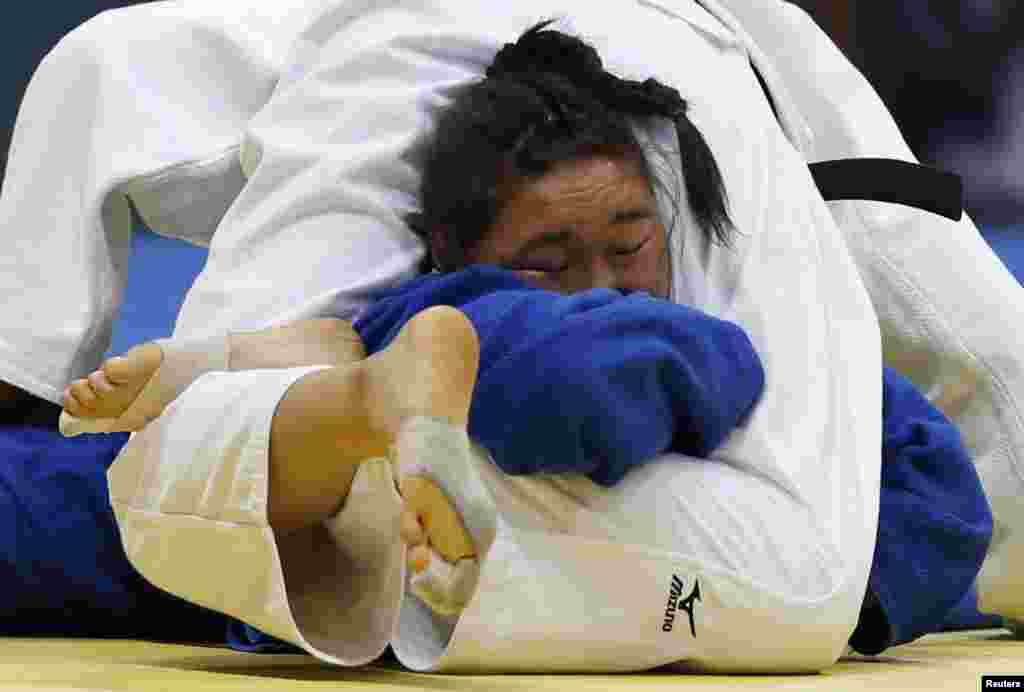 Japan's Mami Umeki competes with Mongolia's Munkhtuya Battulga (blue) during their women's -78 kg bronze medal judo contest at the Dowon Gymnasium during the 17th Asian Games in Incheon, South Korea.