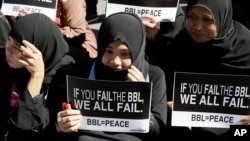 Filipino Muslims display messages during a rally at the Lower House to call for the passage of Bangsamoro Basic Law, or BBL, in Quezon city, northeast of Manila, Tuesday, Feb. 10, 2015.