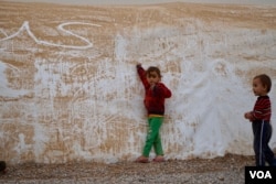 Two youngsters from Mosul play during a sandstorm in the Khazir camp for displaced civilians. (J. Dettmer/VOA)