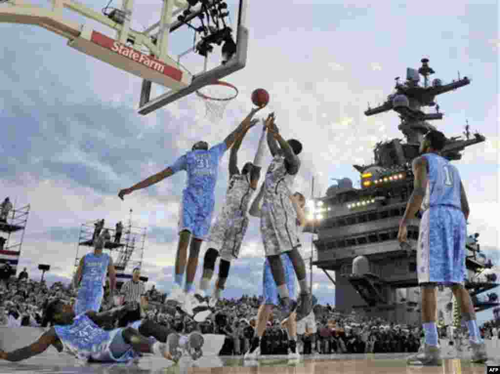 North Carolina forward John Henson (31) fights for a rebound with Michigan State center Adreian Payne (5) and forward Branden Dawson (22) during the first half of the Carrier Classic NCAA college basketball game aboard the USS Carl Vinson, Friday, Nov. 11