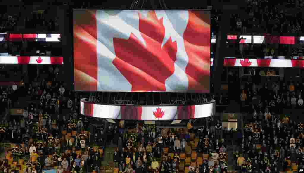 Fans stand up for the Canadian national anthem prior to an NHL hockey game between the Boston Bruins and New York Islanders in Boston. The tribute was for Cpl. Nathan Cirillo, 24, who was killed by a gunman who shot him at Canada&#39;s National War Memorial in Ottawa, Oct. 23, 2014. 