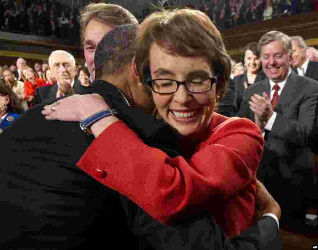 奥巴马总统拥抱众议员吉福兹女士。吉福兹即将辞职，专心疗养。她去年在图森枪击事件中受伤。(AP)