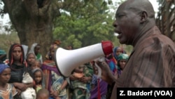 Ibrahim Abaka, the president of an internally displaced persons camp, uses a megaphone to organize the distribution of food aid in Bambari, Jan. 2017.