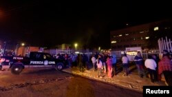 Family members of inmates stand outside the Topo Chico prison near Monterrey, Mexico, Feb. 11, 2016, following reports of rioting that is said to have killed dozens of people.