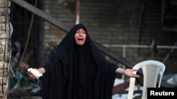 A woman reacts at the site of a car bomb attack that killed a parliament member and 24 others Tuesday, at the entrance to the Shi'ite neighborhood of Kadhimiya in Baghdad, Oct. 15, 2014. 