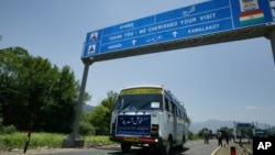 FILE - An Indian bus carrying passengers who arrived from the Pakistani side of Kashmir leaves the border at Chakka Da Bagh in Poonch district, 250 kilometers northwest of Jammu, India.