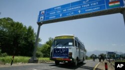 FILE - An Indian bus carrying passengers who arrived from the Pakistani side of Kashmir leaves the border at Chakka Da Bagh in Poonch district, 250 kilometers (156 miles) northwest of Jammu, India.