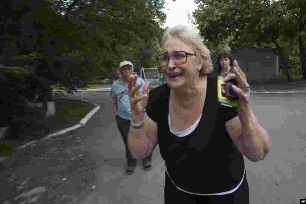 A woman reacts after seeing the lifeless body of a man killed by shrapnel following a shelling from Ukrainian government forces in Slovyansk, Ukraine, May 26, 2014.