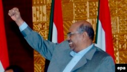 Le président soudanais Omar el-Béchir lève le point lors d’une réunion avec le leader de l’opposition de son pays Mohammed Osman al-Mirghani (non visible sur la photo) à Khartoum, Soudan, 12 novembre 2008. EPA/PHILIP DHIL