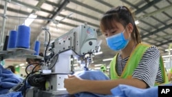 In this Oct. 24, 2017, photo, a garment worker sews clothes at Pro Sports factory in Nam Dinh province, Vietnam. (AP Photo/Hau Dinh)