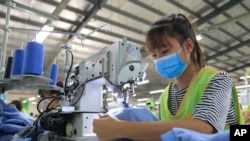 In this Oct. 24, 2017, photo, a garment worker sews clothes at Pro Sports factory in Nam Dinh province, Vietnam. (AP Photo/Hau Dinh)