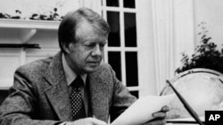 FILE - President Jimmy Carter is shown in this White House photo at work in the White House's Oval Office, in Washington, in 1977. 