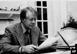 President Jimmy Carter is shown in this White House photo at work in the White House's Oval Office in 1977. (AP Photo/White House/files)