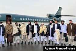 Foto selebaran menunjukkan Menteri Luar Negeri Taliban Amir Khan Muttaqi (tengah), pejabat senior Taliban Anas Haqqani (kanan) dan delegasi, di Bandara Kabul, 22 Januari 2022. (Foto: AFP)