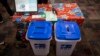 Une nouvelle machine à voter devant être utilisée lors des élections en République démocratique du Congo (RDC) est installée sur une table à côté de deux urnes le 21 février 2018 à Kinshasa.