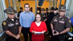 Kim Davis (C) na mwanae Nathan Davis wakizungukwa na mapolisi wa kaunti ya Rowan, alipozungumza na vyombo vya habari huko Kentucky, Sept. 14, 2015.