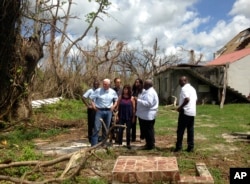 Vice President Mike Pence, joined by his wife Karen Pence, fourth from left, surveys hurricane damage outside Holy Cross Episcopal Church in St. Croix, U.S. Virgin Islands, Oct. 6, 2017.