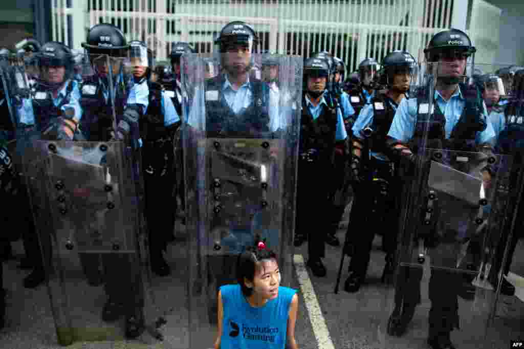 2019年6月12日，香港立法會外，一名抗議者坐在防暴警察面前。