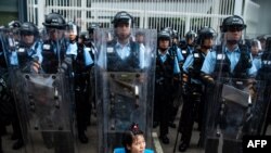 2019年6月12日，香港立法会外，一名抗议者坐在防暴警察面前。