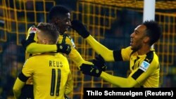 Marco Reus, numéro 11, jubile avec ses coéquipiers du Borussia Dortmund Ousmane Dembele, à gauche, et Pierre-Emerick Aubameyang, à droite, après un but au cours d’un match de la Bundesliga allemande, 3 décembre 2016.