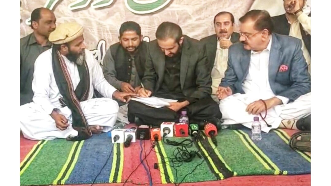 وزیرِ اعلیٰ بلوچستان عبدالقدوس بزنجو دھرنا عمائدین کے ساتھ ہونے والے معاہدے پر دستخط کر رہے ہیں۔