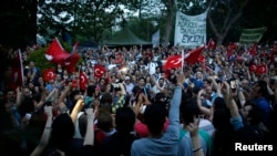 Turkish protesters sing and shout slogans during a demonstration at Taksim Square in Istanbul, June 5, 2013. 
