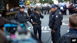 Officers watch over the scene outside the Time Warner Center, Oct. 24, 2018, in New York. Law enforcement officials say a suspicious package that prompted an evacuation of CNN's offices is believed to contain a pipe bomb.