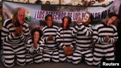 Demonstrators dressed as Peruvian politicians in prisoner clothing protest against engineering group Odebrecht in Lima, Peru, Jan. 19, 2017.