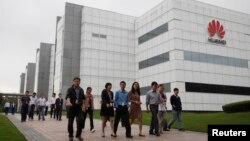 华为技术有限公司的员工走过广东省深圳市的公司办公楼（2012年4月17日）。
