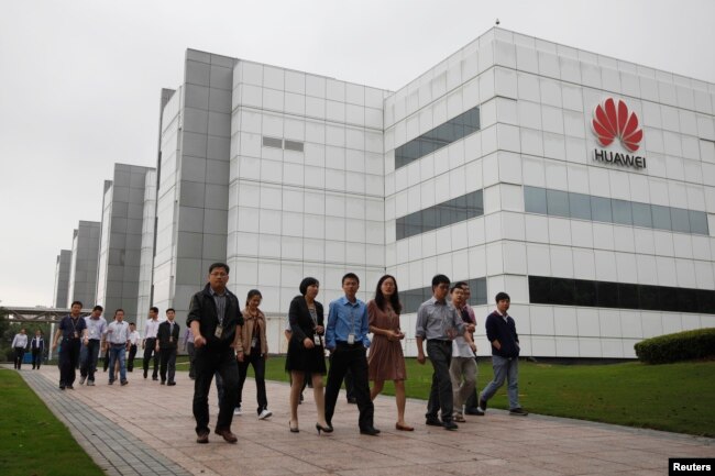 华为技术有限公司的员工走过广东省深圳市的公司办公楼（2012年4月17日）。