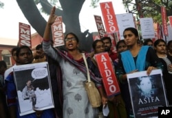 FILE - A member of a students organization shouts slogans as others carry placards asking justice for Asifa, an 8-year-old girl who was raped and murdered, during a protest in Bangalore, India, Apr. 13, 2018.