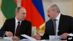 FILE - Russian President Vladimir Putin, left, and visiting Belarus' counterpart Alexander Lukashenko speak to each other a meeting in Moscow's Kremlin, Russia, Dec. 25, 2013.