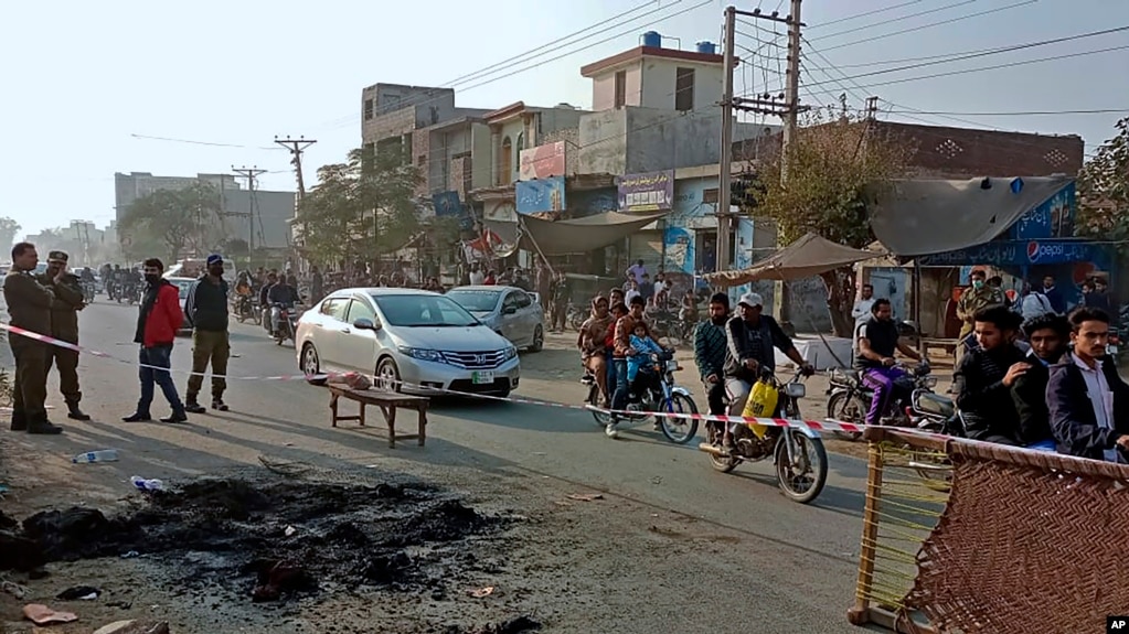 Petugas polisi berjaga di lokasi di mana seorang warga Sri Lanka digantung oleh massa Muslim di luar sebuah pabrik di Sialkot, Pakistan, 3 Desember 2021. (Foto: AP/Shahid Akram)