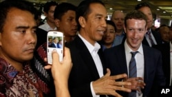 Indonesian President-elect Joko Widodo, center, speaks with Facebook CEO Mark Zuckerberg, right, during their visit to a market in Jakarta, Indonesia, Oct 13, 2014. 